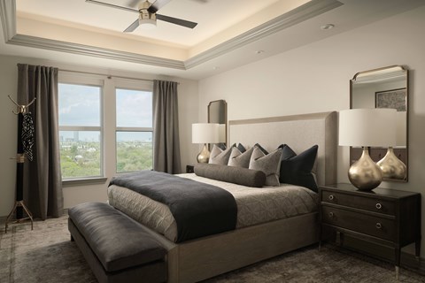 A bedroom with a large bed and a ceiling fan.