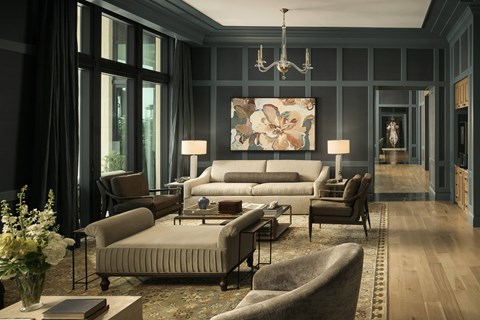 A living room with a grey couch and a chandelier.