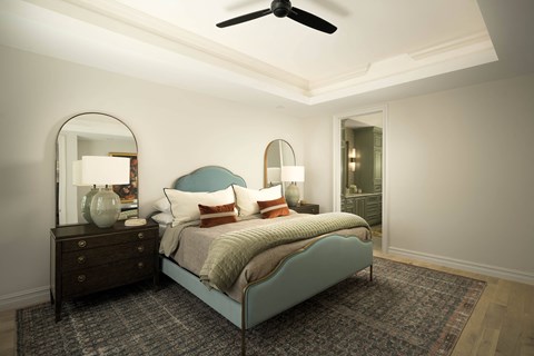 A bedroom with a bed, dresser, mirror, and rug.