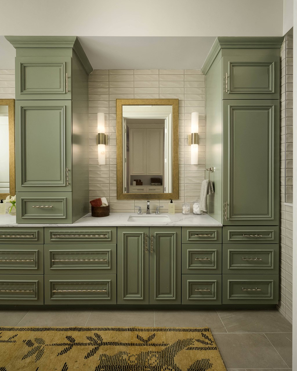 A bathroom with green cabinets and a mirror.