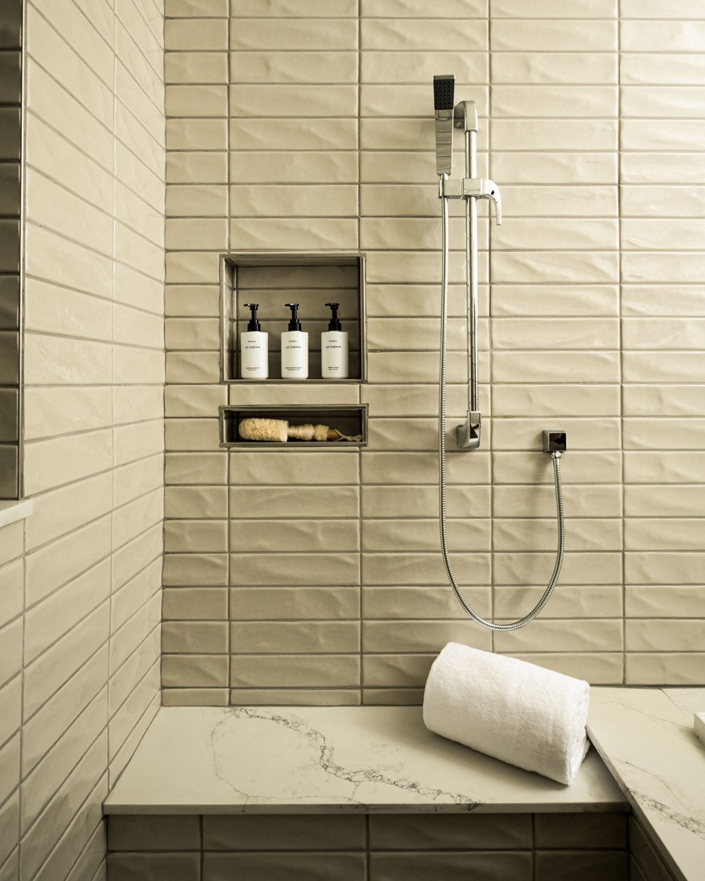 A bathroom with a marble counter top and a shower with a glass door.