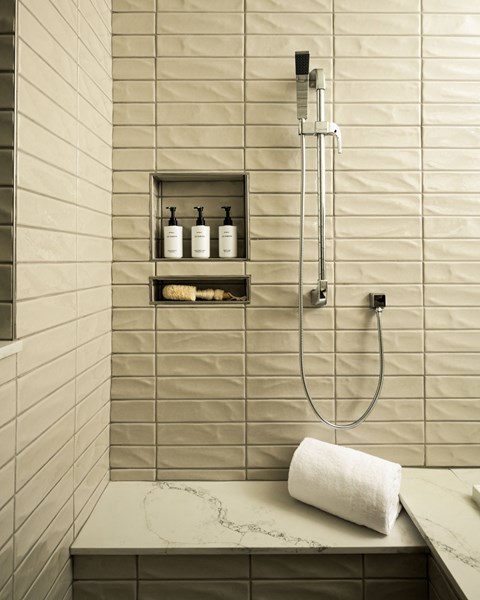 A bathroom with a marble counter top and a shower with a glass door.