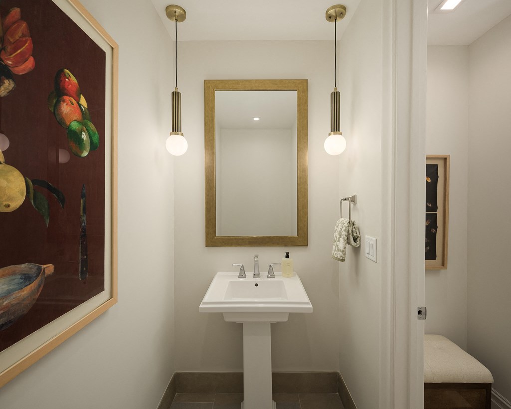 A bathroom with a white sink and a mirror.