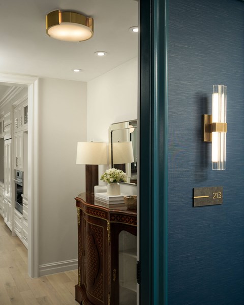 A lamp sits on a table in a room with a blue wall.