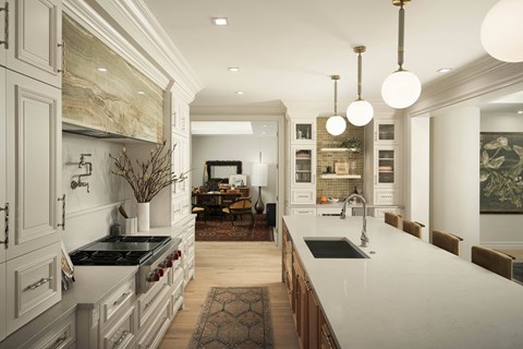 A modern kitchen with a marble backsplash and a large island.
