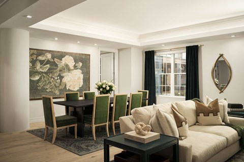 A living room with a large painting of white flowers on the wall.