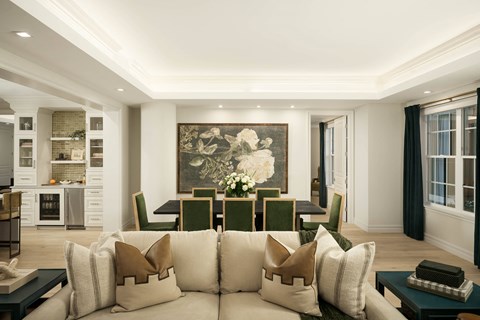 A living room with a large painting on the wall and a sofa with throw pillows.