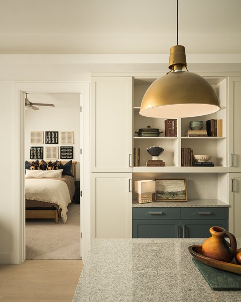 a bedroom with a bed and a kitchen with a counter top