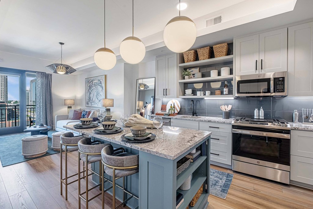 an open kitchen and living room with a island and bar stools