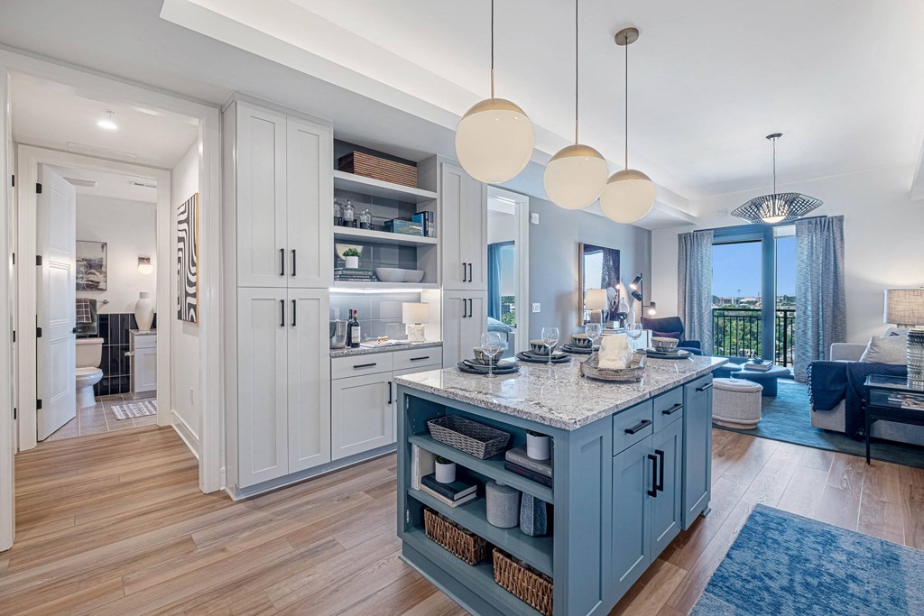 a kitchen with a blue island and a living room
