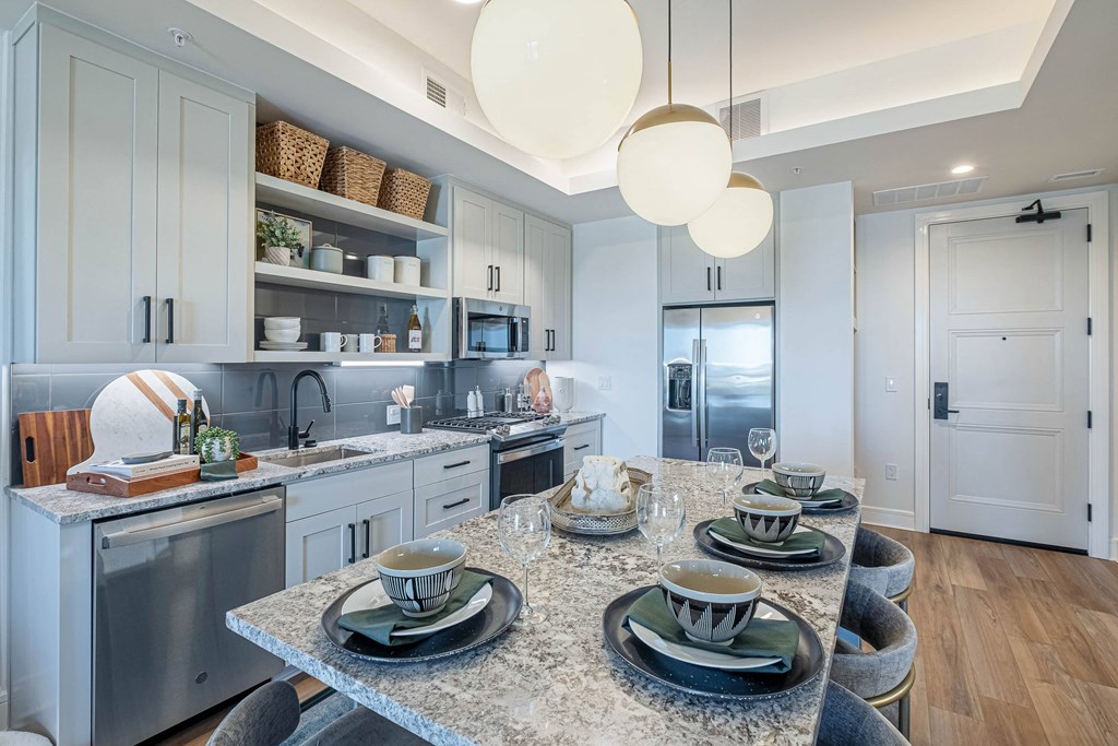 an open kitchen and dining room with a granite counter top