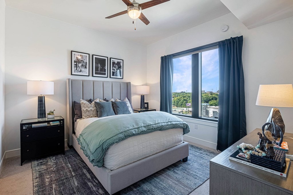 a bedroom with a large window and a bed