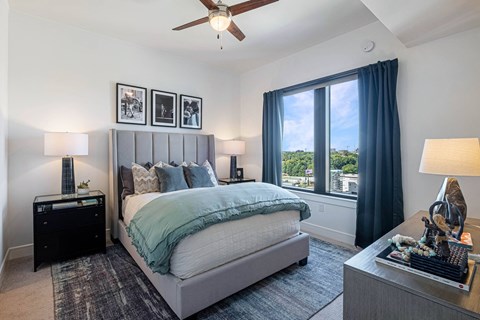 a bedroom with a large window and a bed