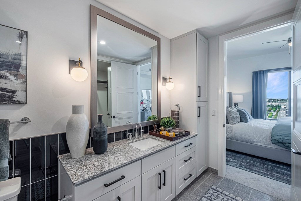 a white bathroom with a large mirror and a sink