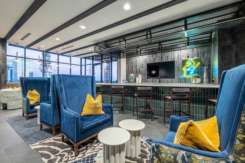 a lobby with blue chairs and a bar with a television
