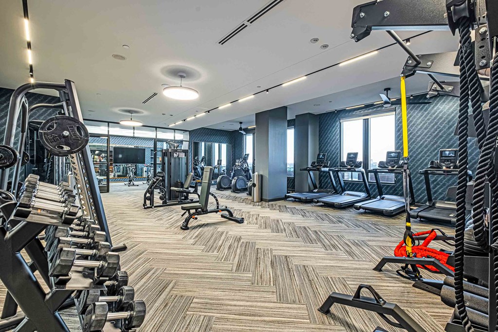 a gym with cardio machines and weights on the floor