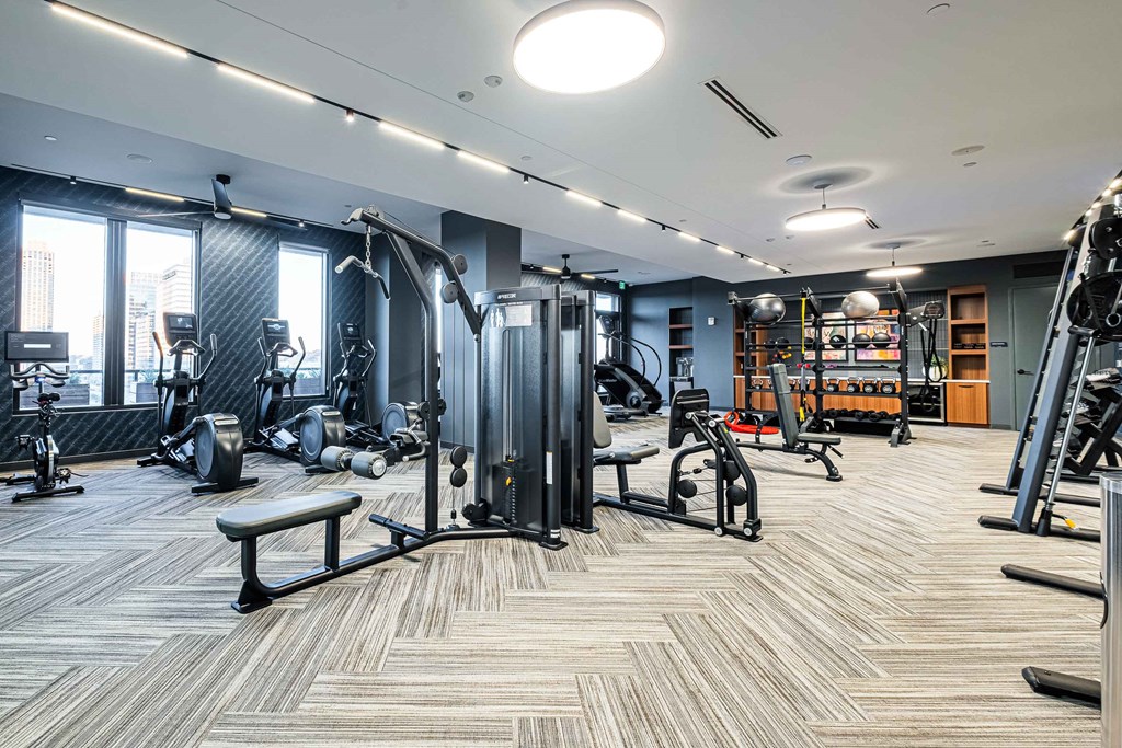 a gym with weights and cardio equipment in a building
