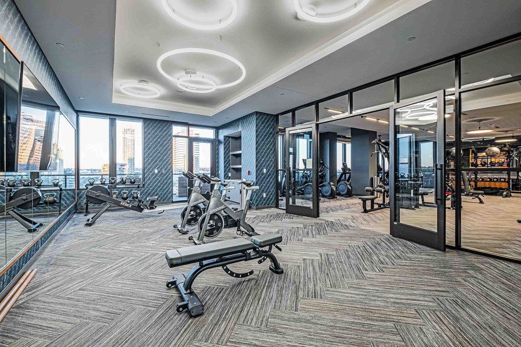 a gym with cardio equipment and glass walls