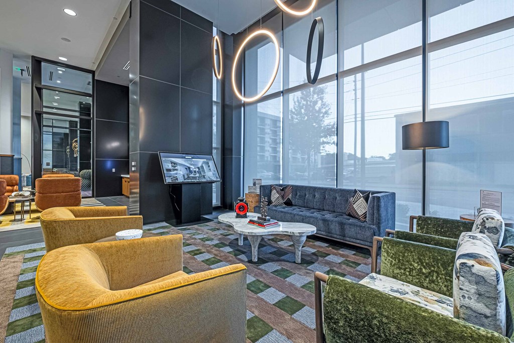 a lobby with couches and chairs and a tv