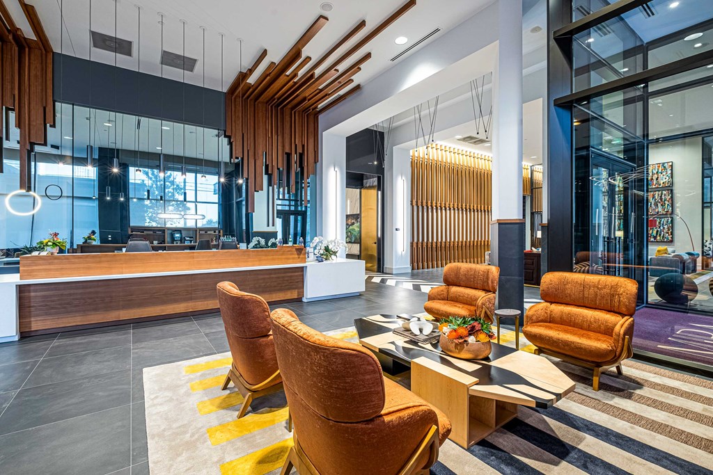 a lobby of a hotel with chairs and a table