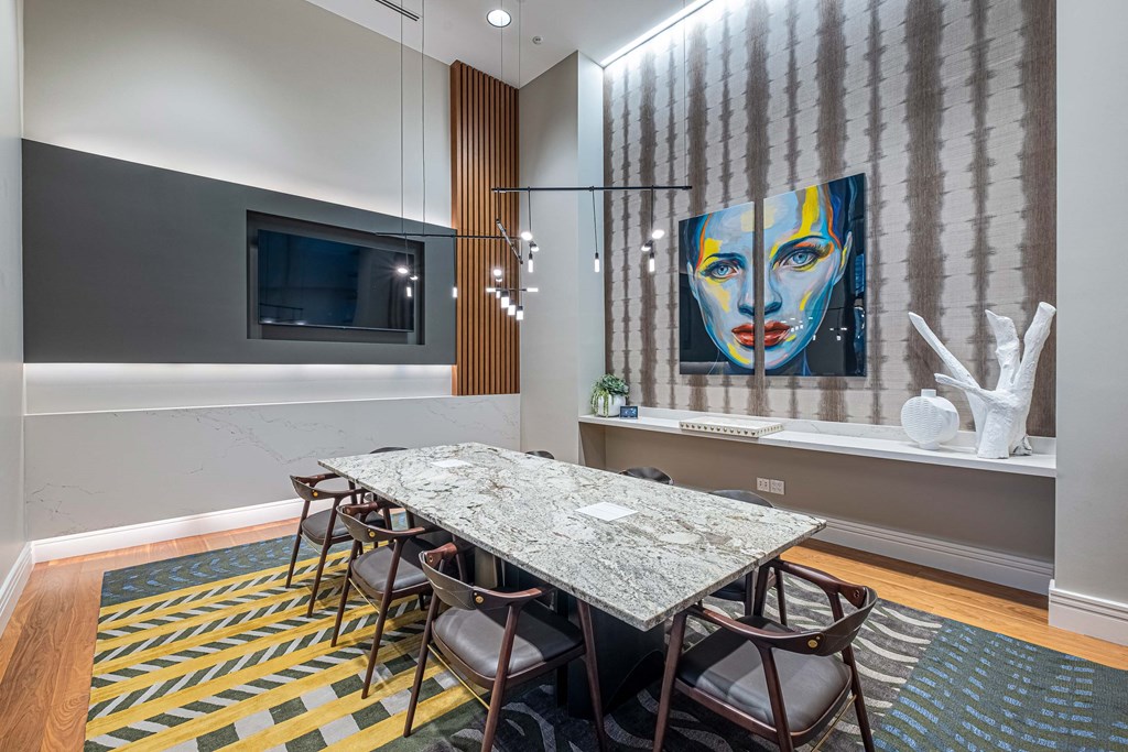 a dining room table with chairs and a painting on the wall
