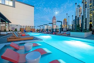 a hotel swimming pool with a city skyline in the background