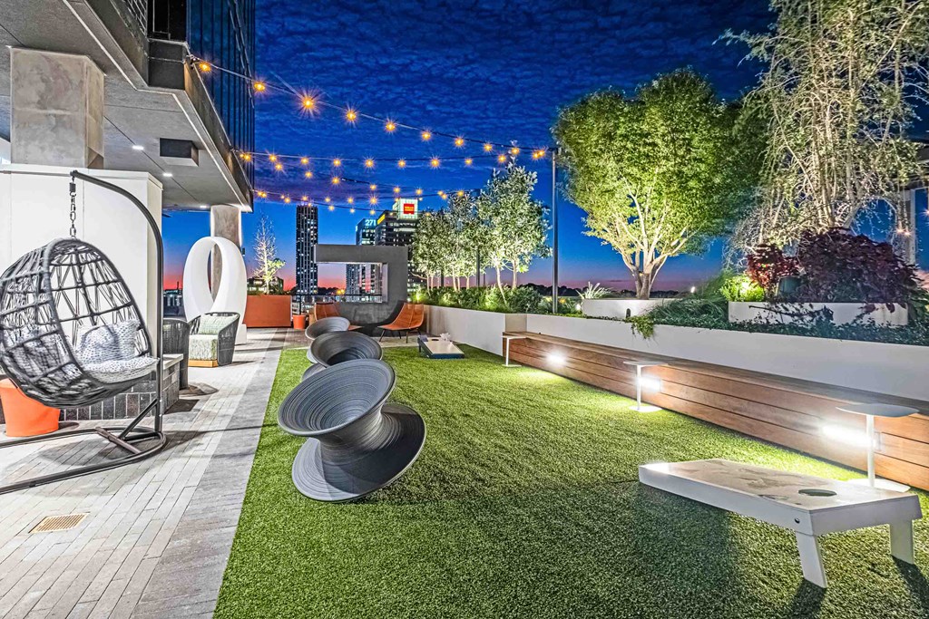 a patio with grass and a view of the city at night