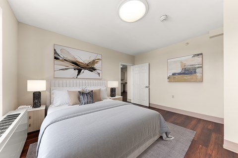 A bedroom with a large bed and a painting of a dragonfly on the wall. at 206 Flats Apartments, Spokane, Washington