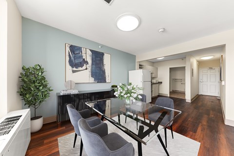 A modern dining room with a glass table and grey chairs at 206 Flats Apartments, Spokane