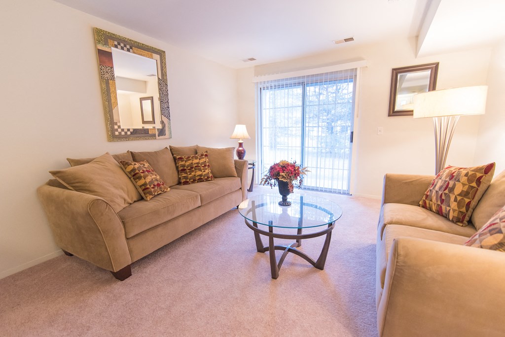 a living room with couches and a glass coffee table