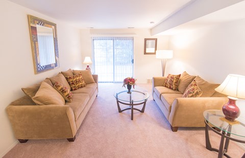 a living room with couches and a glass coffee table