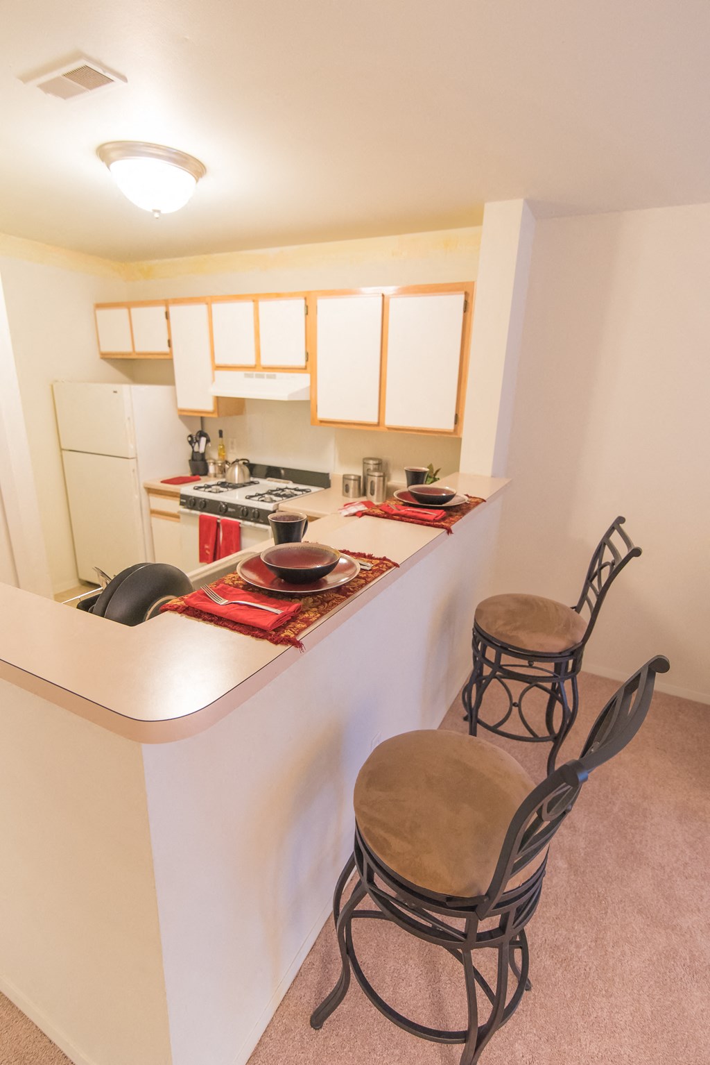 a kitchen with a bar and two stools