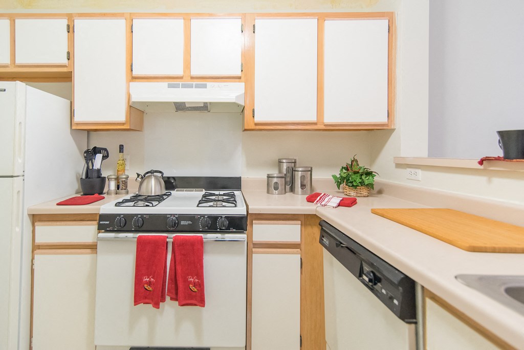 a kitchen with white appliances and wooden cabinets
