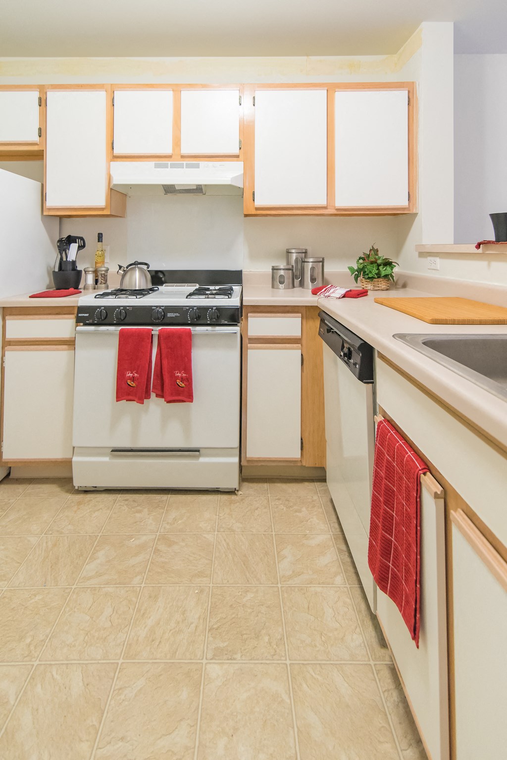 a kitchen with white appliances and white cabinets and towels on the stove