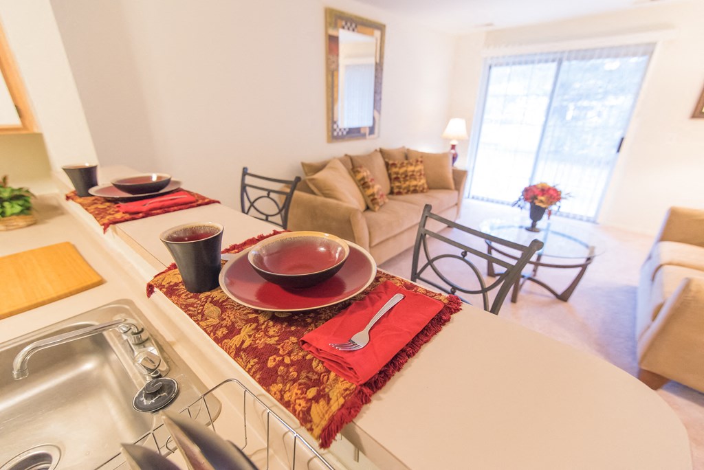 a kitchen and living room with a dining table and a sink