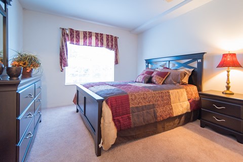 a bedroom with a bed and a dresser and a window