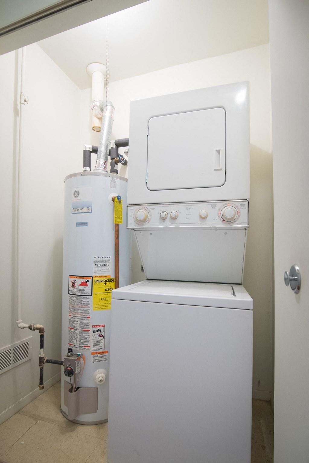 a white washer and dryer in a room with a water heater