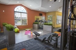 a gym with exercise equipment and a large window