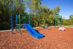 a playground with a blue slide and a pink pig