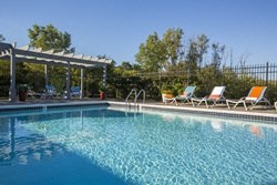 a large swimming pool with chairs and a canopy