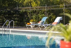 a swimming pool with two lounge chairs next to it