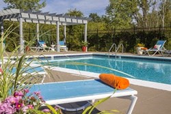 a pool with an orange cushion on a poolside table