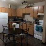 a kitchen with a table and chairs and a refrigerator