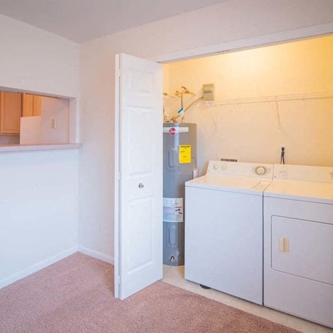 a white laundry room with two washes and a dryer
