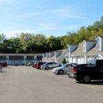a parking lot filled with cars in front of houses