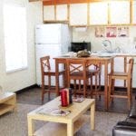 a kitchen and a dining room with a table and chairs