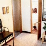 a living room with a piano and a door to a bathroom