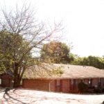 a red brick house with a tree in front of it