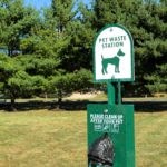 a sign for a dog park in a field