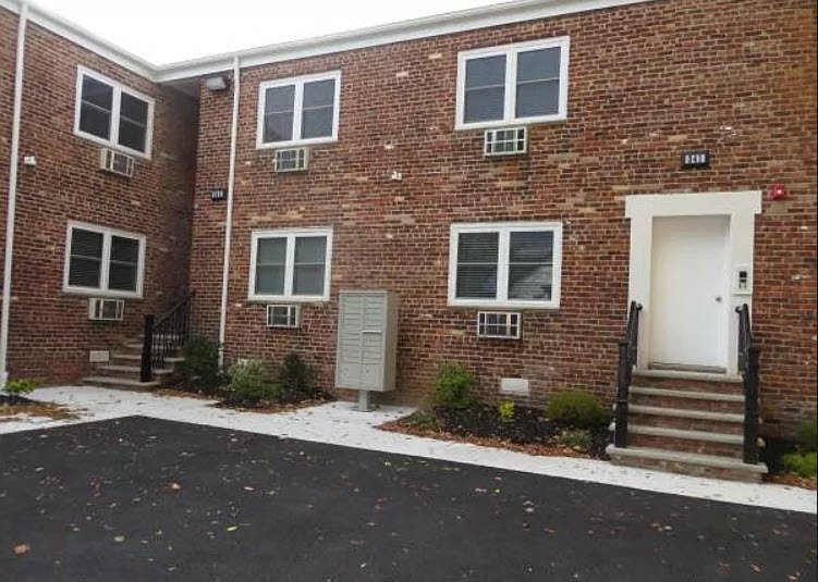 a brick building with a white door and stairs